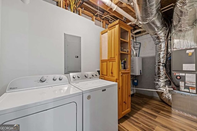 laundry area featuring light hardwood / wood-style flooring, electric panel, cabinets, tankless water heater, and washing machine and clothes dryer