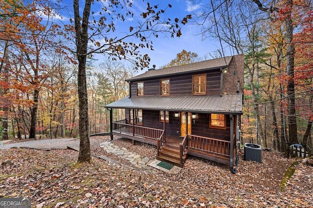 log home with cooling unit and a porch