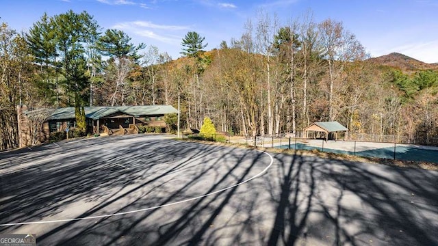 exterior space featuring a mountain view and basketball hoop