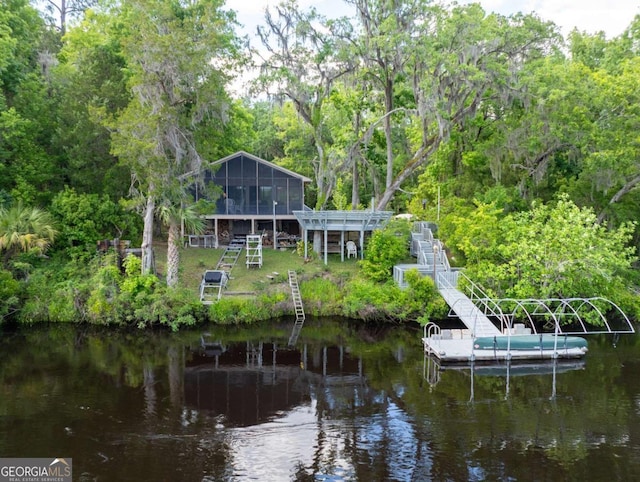 rear view of house with a sunroom and a water view