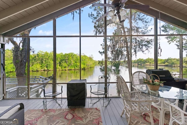 sunroom / solarium featuring lofted ceiling with beams, ceiling fan, and a water view