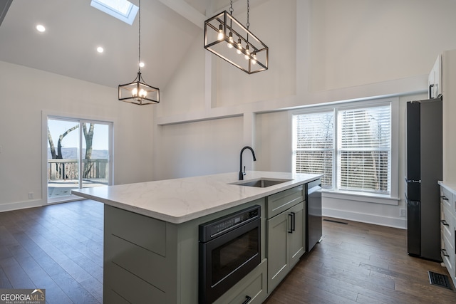 kitchen with black appliances, a healthy amount of sunlight, sink, and an island with sink