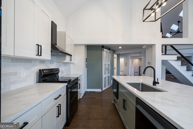 kitchen featuring sink, wall chimney range hood, dark hardwood / wood-style flooring, white cabinets, and black appliances