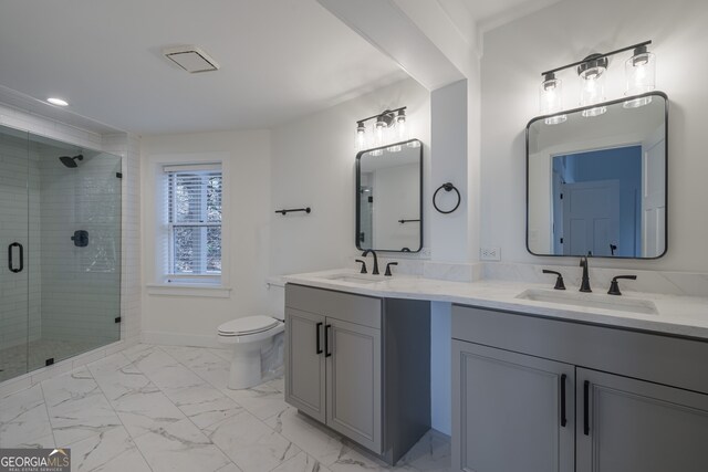 bathroom with vanity, toilet, and a shower with shower door