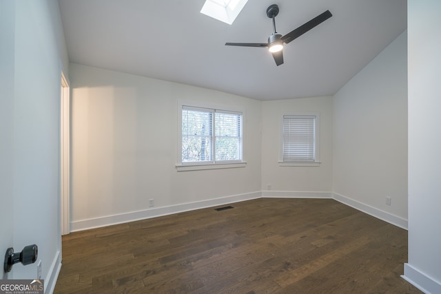 unfurnished room with dark hardwood / wood-style floors, ceiling fan, and lofted ceiling with skylight