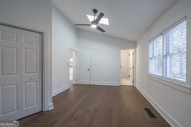 hall with dark wood-type flooring and vaulted ceiling