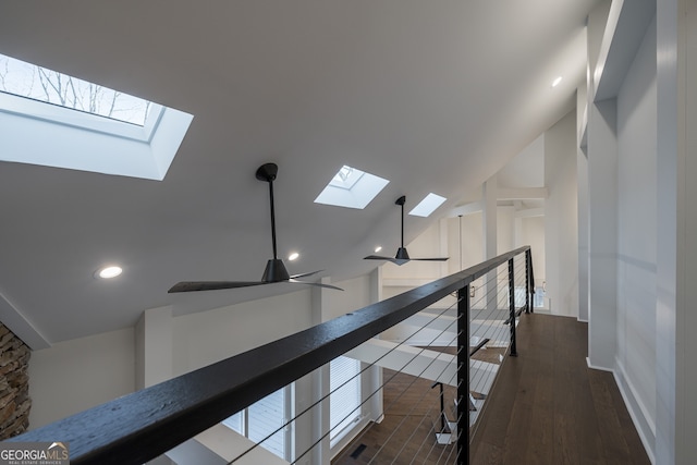 hall with dark hardwood / wood-style flooring and vaulted ceiling with skylight