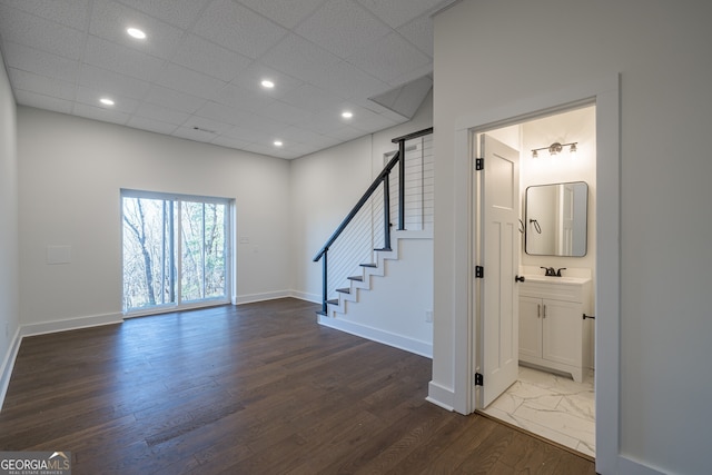 interior space with a paneled ceiling, dark hardwood / wood-style flooring, and sink