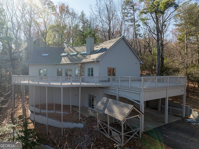 rear view of property featuring a patio area and a wooden deck