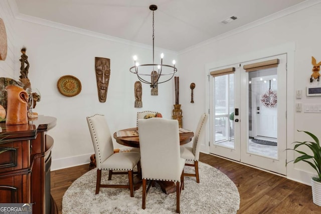 dining space with a chandelier, dark hardwood / wood-style flooring, ornamental molding, and french doors