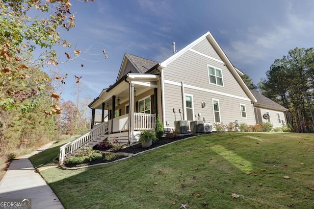 view of home's exterior with cooling unit, covered porch, and a yard