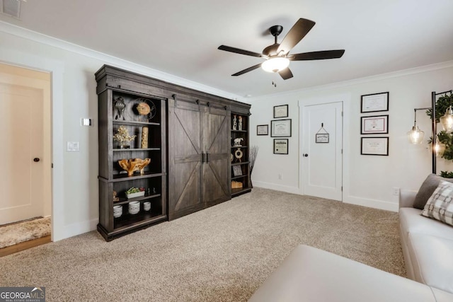 living room with carpet flooring, a barn door, crown molding, and ceiling fan