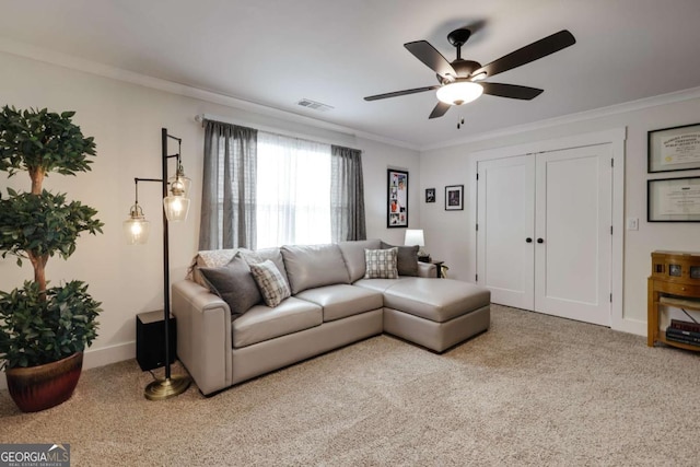 carpeted living room featuring ceiling fan and ornamental molding