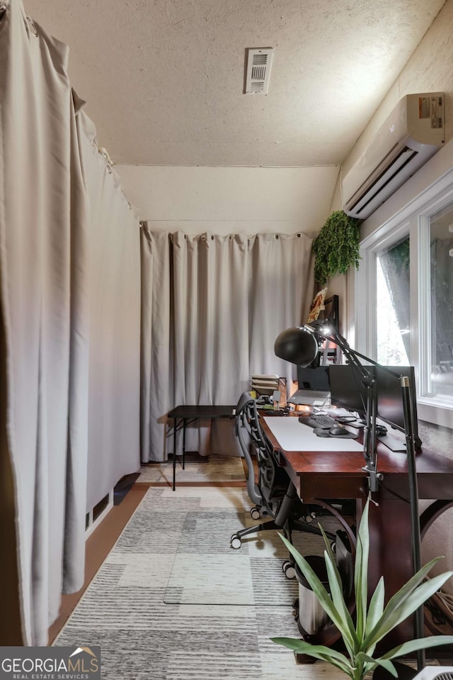 office area featuring lofted ceiling, a textured ceiling, and a wall mounted AC