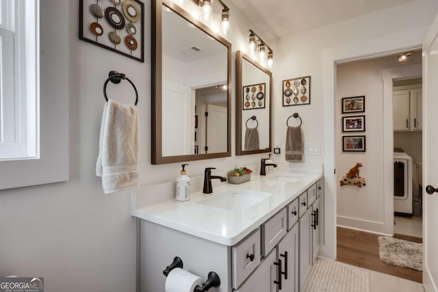 bathroom featuring vanity, hardwood / wood-style flooring, and washer / clothes dryer