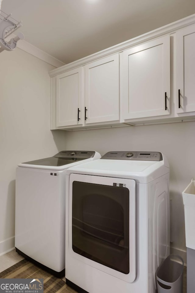 washroom featuring separate washer and dryer, crown molding, and cabinets