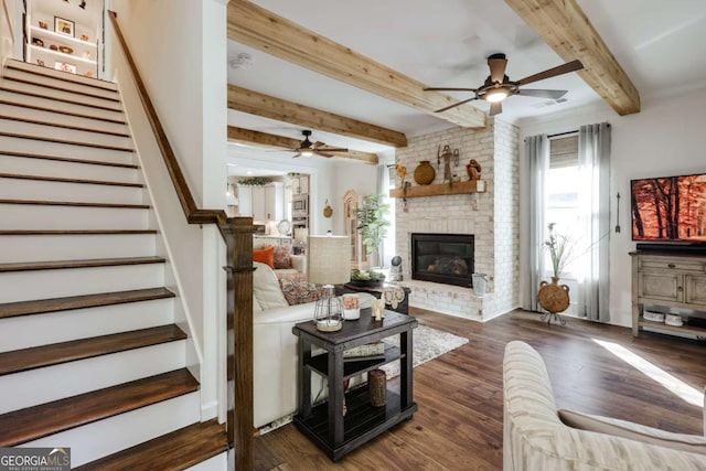 living room featuring a fireplace, beam ceiling, dark hardwood / wood-style flooring, and ceiling fan