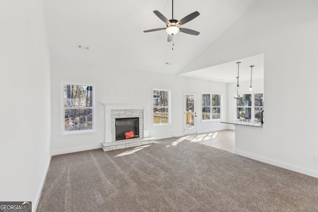 unfurnished living room featuring light colored carpet, a fireplace, high vaulted ceiling, and ceiling fan