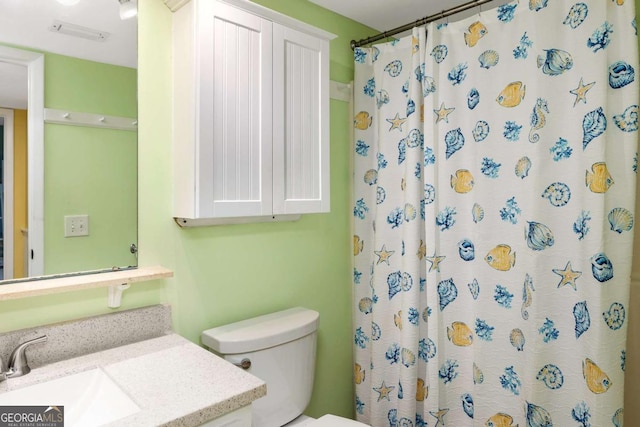 bathroom featuring a shower with shower curtain, vanity, and toilet