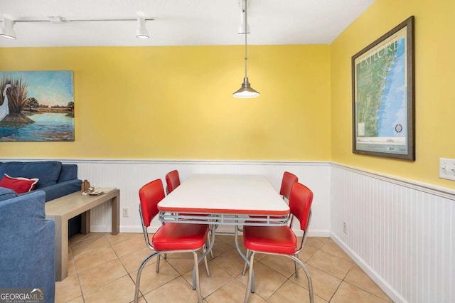 tiled dining area featuring rail lighting