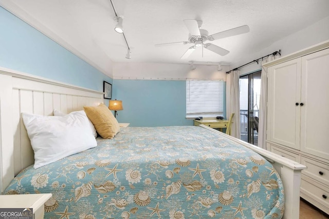 bedroom featuring rail lighting and ceiling fan