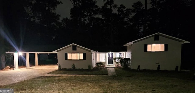 view of front of house featuring a lawn and a carport