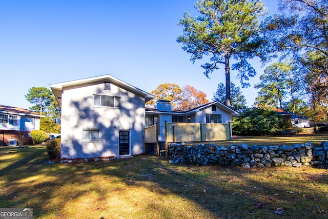 back of property featuring a yard and a wooden deck