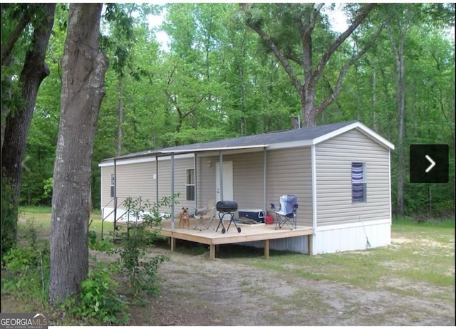 rear view of property featuring a wooden deck