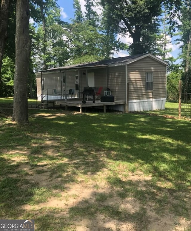 rear view of property with a lawn and a deck