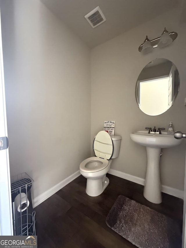 bathroom featuring wood-type flooring and toilet