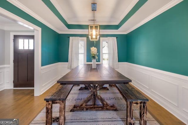 dining room featuring ornamental molding, hardwood / wood-style flooring, and a healthy amount of sunlight