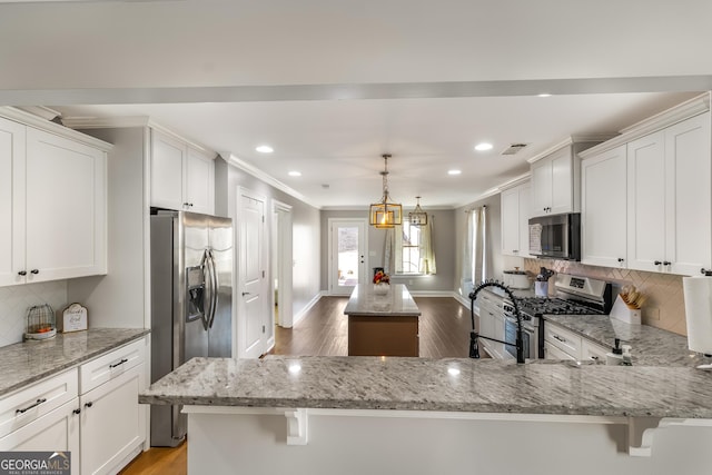 kitchen with white cabinetry, kitchen peninsula, and appliances with stainless steel finishes