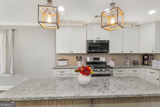 kitchen featuring white cabinets, appliances with stainless steel finishes, a kitchen island, and pendant lighting