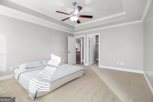 bedroom with a walk in closet, a tray ceiling, ceiling fan, crown molding, and carpet floors