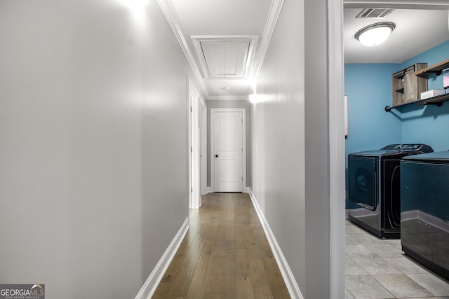 hallway featuring separate washer and dryer, crown molding, and light hardwood / wood-style flooring