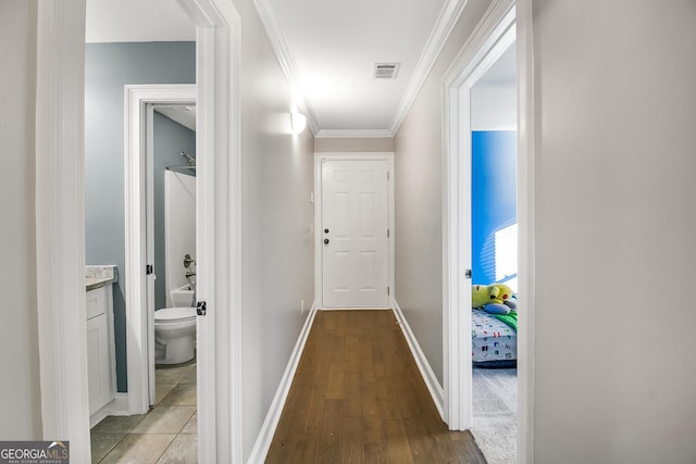 hall with light wood-type flooring and crown molding