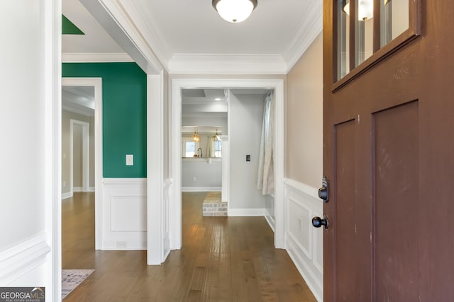 foyer with dark wood-type flooring and ornamental molding