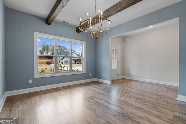 spare room with a chandelier, beam ceiling, and hardwood / wood-style flooring