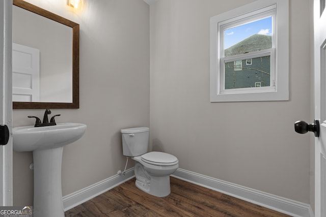 bathroom featuring toilet, wood-type flooring, and sink