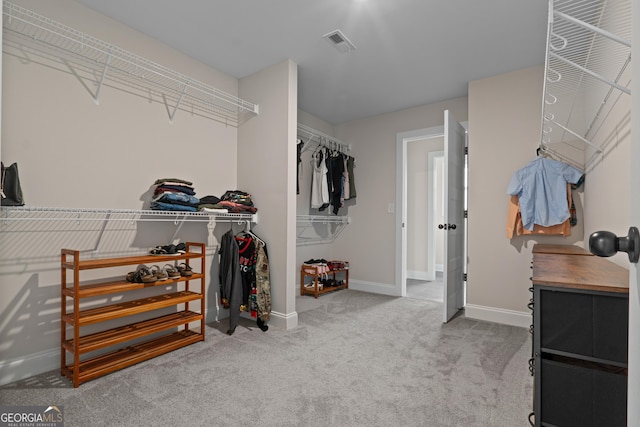 walk in closet featuring light carpet