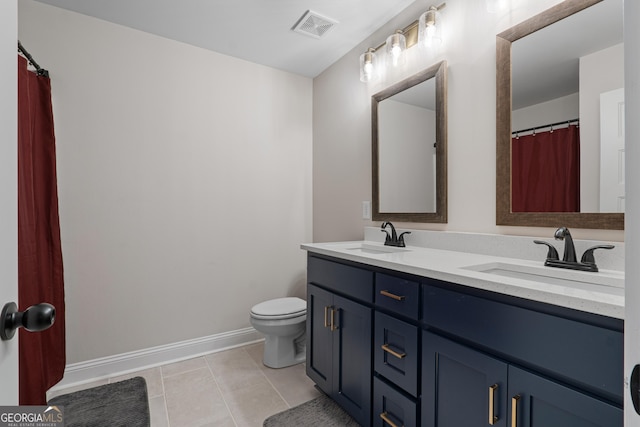 bathroom featuring tile patterned flooring, vanity, and toilet