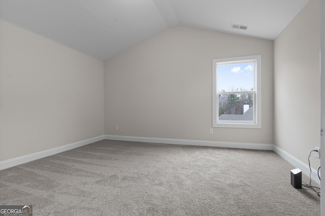 additional living space featuring light carpet and vaulted ceiling