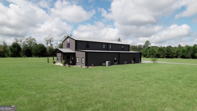 rear view of property with a lawn and central AC unit