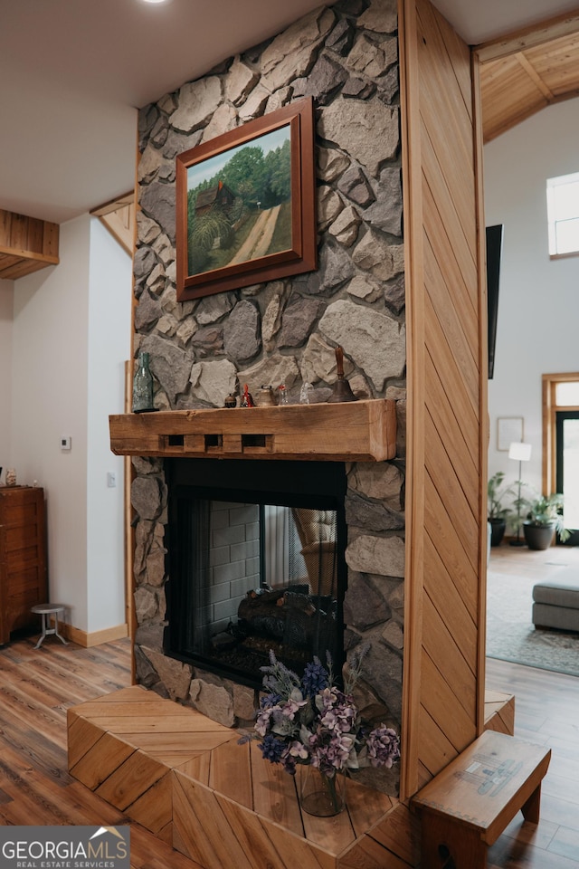 room details with a stone fireplace and hardwood / wood-style floors