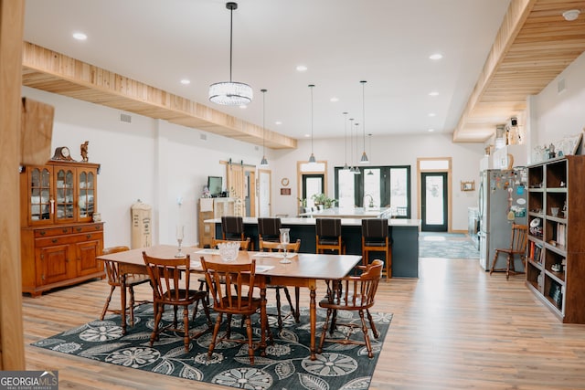 dining room with light hardwood / wood-style flooring and a notable chandelier