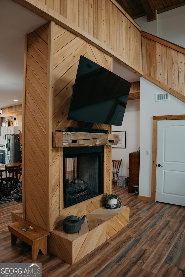 living room with a multi sided fireplace, vaulted ceiling with beams, and dark hardwood / wood-style flooring