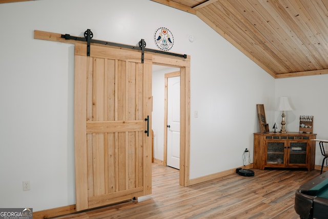 interior space featuring wood-type flooring, a barn door, lofted ceiling, and wood ceiling