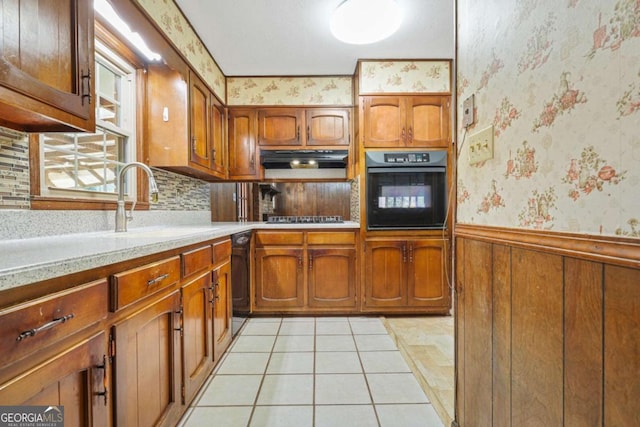 kitchen with light tile patterned flooring, decorative backsplash, sink, and black appliances