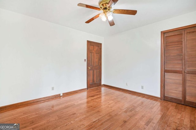 unfurnished bedroom featuring a closet, light hardwood / wood-style flooring, and ceiling fan