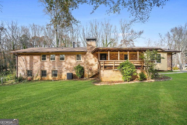 rear view of house featuring a yard and a wooden deck